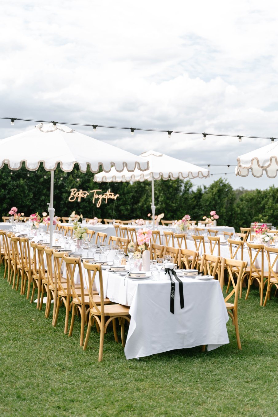 A long table on the lawn under festoon lights