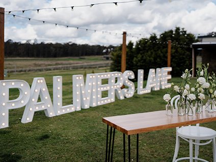 Palmers Lane marquee letters beside a bar table on the lawn