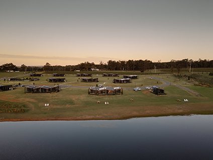 The Lane Retreat studios from the air at dusk beside the water