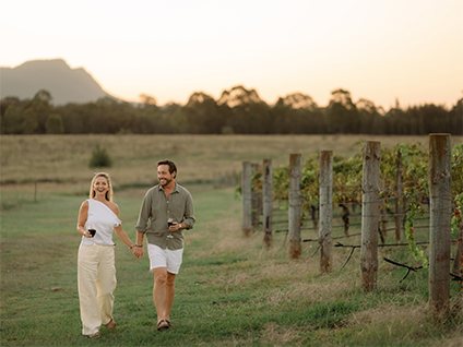 A couple walking the vine rows at Palmers Lane at golden hour